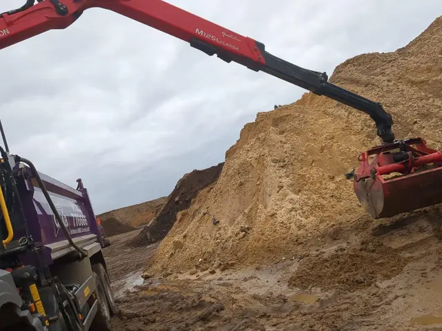 Grab lorry hydraulic arm loading soil on a Castle Lane area job